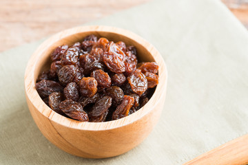 Raisins on a wood background.