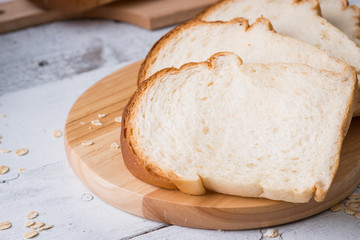 Fresh baked bread and sliced bread on rustic wooden table