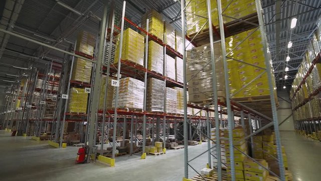 Logistic warehouse, movement of the chamber between the shelves in the warehouse, shelves and racks with boxes.
