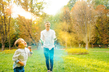 Fototapeta premium Fathers and children in the park palys with holi paints