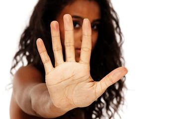 portrait of a young dark-skinned woman showing stop hand on a white background