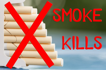 Concept. Smoke kills. Open pack of cigarettes. Green blur background, closeup, selective focus.