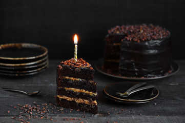 Chocolate cake with birthday candle on the rough wooden table