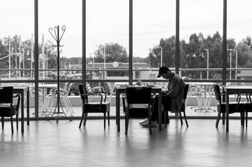 young man with the phone at the table near the window