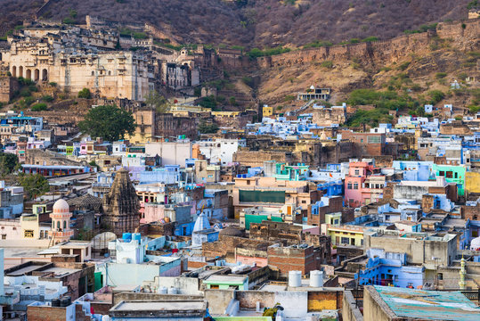 Bundi cityscape, travel destination in Rajasthan, India. The majestic fort perched on mountain slope overlooking the blue city.  Wide angle view.