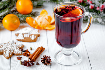 Christmas mulled wine with spices in cup on wooden background