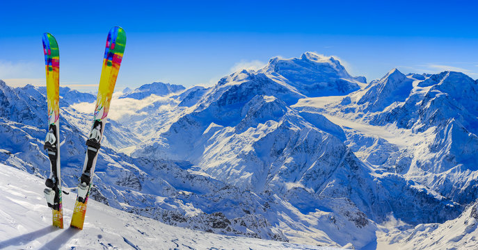 Skiing in winter season, mountains and ski equipments on the top of snowy mountains in sunny day. Swiss Alps.