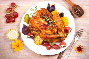 Whole chicken with honey, fruits, vegetables and berries: figs, corn on cob, grape, plums and blackberry. View from above, top, horizontal