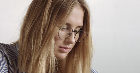 Beautiful young professional blond in glasseswoman portrait office style