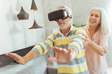 Positive loving aged couple testing VR glasses