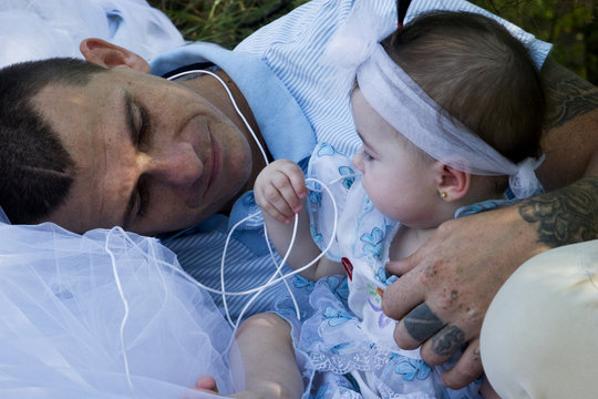 Little daughter playing with his father on nature