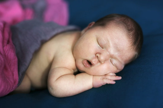 sweet newborn baby sleeps on stomach, dark