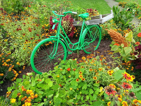 Grünes Fahrrad als Dekoration in einem grünen Park mit Blumenbeet im Sommer im Landschaftspark in Oelde bei Warendorf im Münsterland in Westfalen