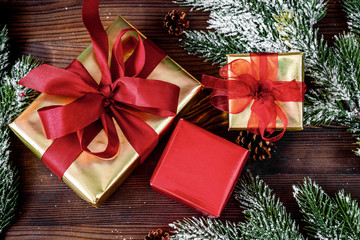 gifts boxes with fir branches on wooden background top view