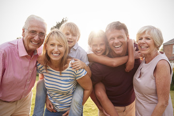 Multi generation family in garden smile to camera, close up