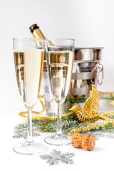 glasses of champagne and Christmas ornaments on white background