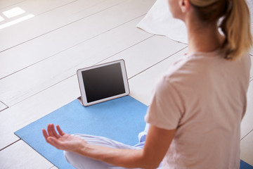 Woman With Digital Tablet Using Meditation App In Bedroom