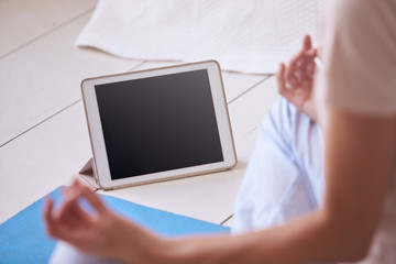 Woman With Digital Tablet Using Meditation App In Bedroom