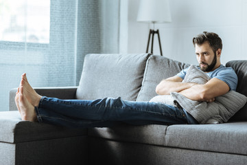 Obraz premium Unhappy depressed man holding a cushion