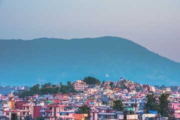 Fototapeta na wymiar Colourful town with high mountains as backdrop