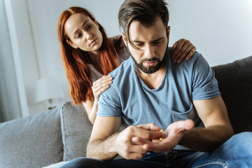Sad depressed man taking his medicine