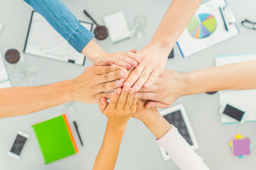 The six people hold hands at the table. view from above