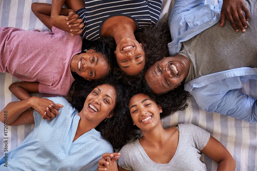 Poster overhead view of family with teenage children lying on bed