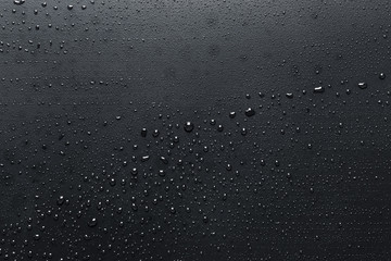 Black drops on a dark surface