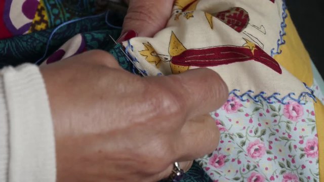 Close up of woman's hand sewing patchwork