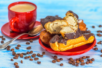 eclairs on a red plate on a wooden background