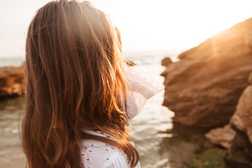 View from back of brunette woman in light summer dress