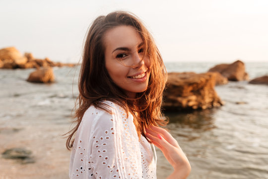 Side view of happy woman in light summer dress posing