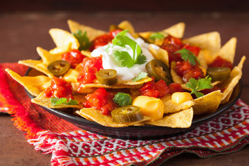nachos loaded with salsa, cheese and jalapeno