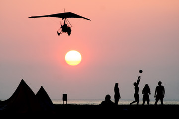 Naklejka na ściany i meble beach sunset scene with people and deltaplane 