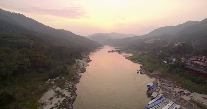 Descending Aerial Shot Of Mekong River And Long Boats At Sunset, Pakbeng, Laos
