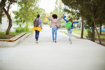 Happy students with arms raised on air
