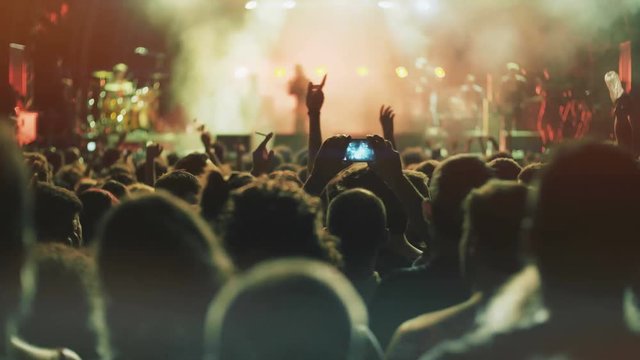 4K UHD Night Rock Concert Front Row Crowd Cheering Hands In Air.Series Of Real Time Close Up Shots From A Night Rock Concert.People Clap Their Hands In Unison Against The Strobing Stage Lights.