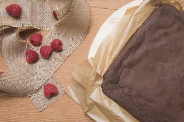 Chocolate brownie bake with raspberries on a wooden background 