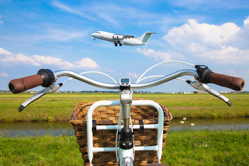 Bicycle near the runway, the plane takes off.