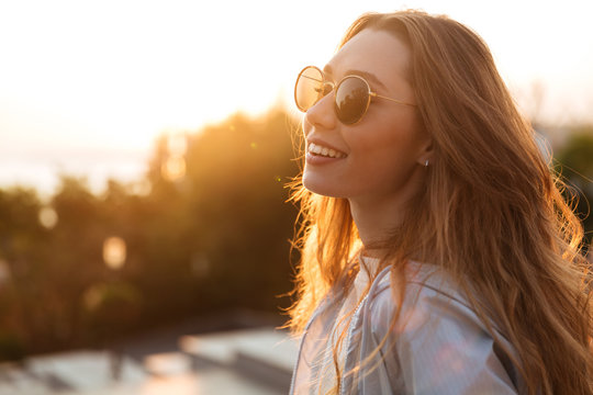 Close up image of happy brunette woman in sunglasses