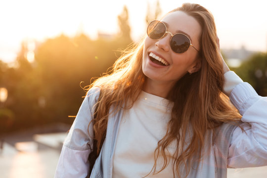 Close up picture of laughing brunette woman in sunglasses