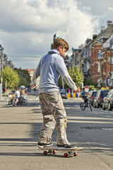 Young teenager boy practice skateboarding during the Car Free Streets day