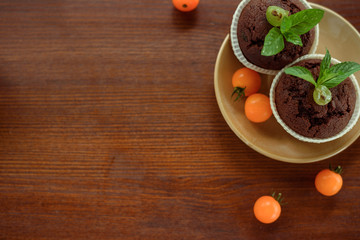 Morning breakfast: blue cup of tea, muffins and physalis on a wooden table