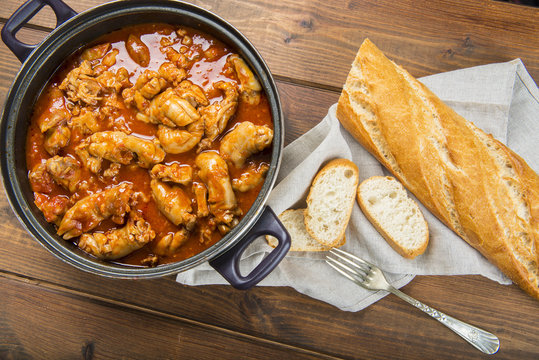 Cacerola con manitas de cochinillo, carne de cerdo en salsa y pan para un delicioso aperitivo o comida