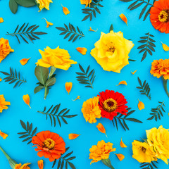 Obraz premium Floral pattern made of flowers and petals on blue background. Flat lay, top view. Floral background.