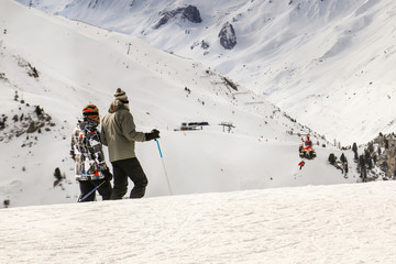 People watching how rescue helicopter evacuates skier after accident during downhill at ski winter...