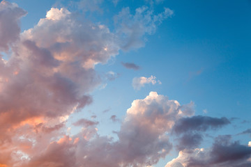 Beautiful sky background with colored clouds at sunset with sun setting down.
