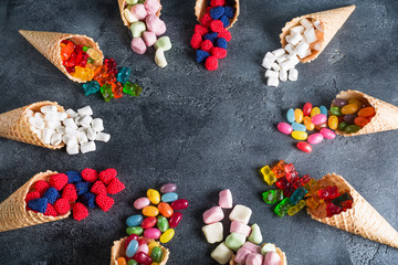 Round frame made of colorful bright assorted candy in waffle cones. Sweety food. Flat lay, top view