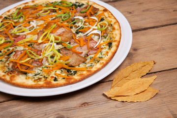 seasonal autumn pizza with onion vegetables carrot pumpkin and bacon