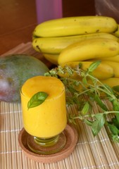 Fresh healthy mango and banana smoothie on a glass. Organic drink.